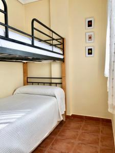 two bunk beds in a room with a tile floor at Apartamento a pie de playa en El Portil in El Portil