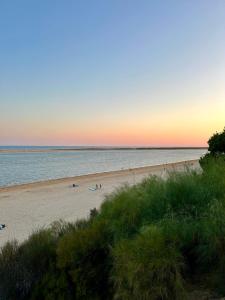 a beach with people on the sand and the ocean at Apartamento a pie de playa en El Portil in El Portil