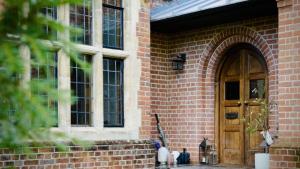 ein Backsteingebäude mit einer Holztür und Fenstern in der Unterkunft Higginson House in Marlow