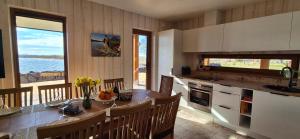 a kitchen with a table and chairs and a kitchen with a view at Jõesuu Puhkemaja saunamaja in Verevi