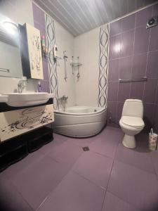 a purple bathroom with a sink and a toilet at SWEET APARTMENT KUTaISI in Kutaisi +7 photos