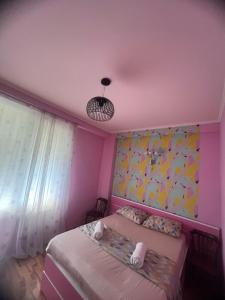 a bedroom with a bed and a pink ceiling at SWEET APARTMENT KUTaISI in Kutaisi