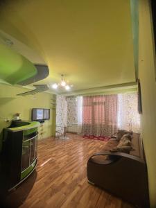 a living room with a couch and a tv at SWEET APARTMENT KUTaISI in Kutaisi