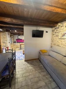 ein Wohnzimmer mit einem Sofa und einem Fernseher an der Wand in der Unterkunft La Casita de Verdiago in Verdiago