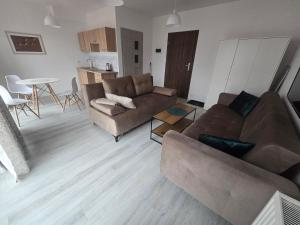 a living room with two couches and a table at Słoneczny Nadmorska in Grzybowo