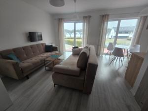 a living room with a couch and a table at Słoneczny Nadmorska in Grzybowo