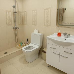a white bathroom with a toilet and a sink at HeyTun Gyumri in Gyumri