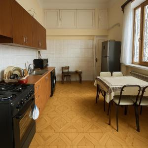 a kitchen with a stove and a table with chairs at HeyTun Gyumri in Gyumri +9 photos