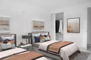 a bedroom with two beds with pillows and a closet at University Luxe Residences in Tampa
