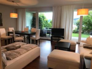 a living room with a table and a dining room at Luxus Seeappartements in Velden am Wörthersee