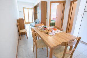 uma cozinha e sala de jantar com uma mesa de madeira e cadeiras em Gemma Pineto Vacanza em Pineto
