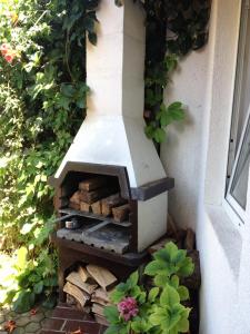 a outdoor wood fired oven is on the side of a house at Studio Ana in Selce