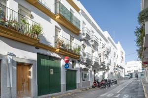 a row of buildings with motorcycles parked on a street at Apartamento Perez Zara 6 in Conil de la Frontera