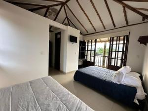 une chambre avec un lit dans une pièce avec des fenêtres dans l'établissement Villa Country Colonial Socorro Santander, à Socorro