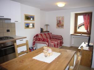 a kitchen with a table and a living room at Le Chaton Fait Ronron in Quart