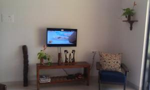 a living room with a tv and a table and a chair at Premium Luxury -1BHK at Candolim Beach with Free Wifi and Pool in Candolim