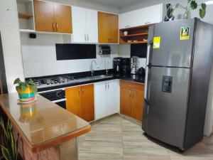 a kitchen with a stainless steel refrigerator and wooden cabinets at Cabaña Rivera in Moniquirá