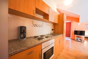 a kitchen with wooden cabinets and a stove top oven at Villa Rocco in Vinjerac