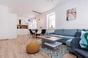a living room with a blue couch and a table at Apartmán NeKLID - Rezidence K Lanovce in Jáchymov