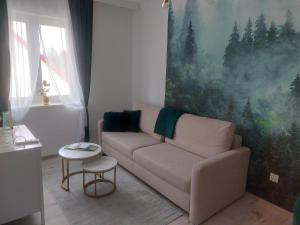 een woonkamer met een bank en een schilderij bij Apartament Górskie Zacisze in Szklarska Poręba