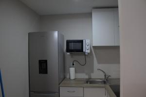 a kitchen with a stainless steel refrigerator and a sink at Apartamento Encanto Marino in Sant Carles de la Ràpita