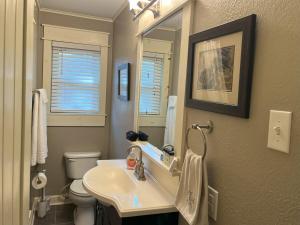 a bathroom with a sink and a toilet and a mirror at Southern Bungalow Charm in Baton Rouge +17 photos