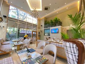 a restaurant with tables and chairs and a person in the background at Hotel Mumbai House Mindspace Malad in Mumbai