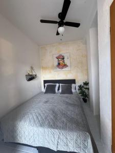a bedroom with a bed with a ceiling fan at Room P&E in Kastel Stafilic