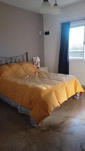 a bedroom with a bed with a yellow blanket on it at Casa Quinta San Miguel del Monte in San Miguel del Monte