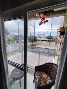 a room with a window with two chairs and a view at Apartamento in São José dos Pinhais