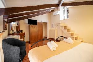 a bedroom with a bed and a chair and stairs at Archontiko Eleni Hotel in Andros