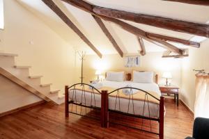 a bedroom with a bed and a staircase at Archontiko Eleni Hotel in Andros