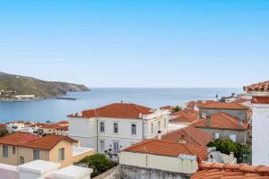 a view of roofs of houses and the ocean at Archontiko Eleni Hotel in Andros
