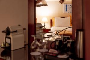 a room with a bed and a desk with a lamp at Archontiko Eleni Hotel in Andros