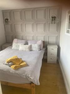 a bedroom with a bed with a white wall at River View Lodge in Caeathro