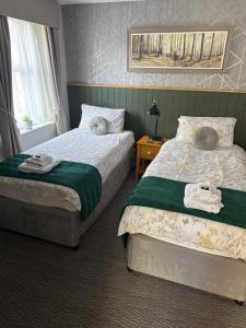 een slaapkamer met twee bedden met handdoeken erop bij The Black Bull Hotel in High Bentham +3 foto's