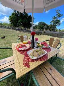 a picnic table under an umbrella with food on it at Dreamvilles Ecovillage Eco Villas with Jacuzzi near Beaches in Las Galeras