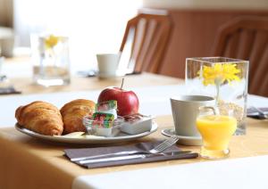 a table with a plate of breakfast food and an apple at Penzión Bojnice in Bojnice