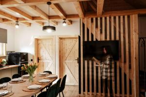 a dining room with a table and a barn door at Domek 5xA in Nałęczów