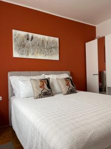 a bedroom with a white bed with orange walls at Apartment Violetta-Punta in Umag