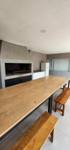 a large wooden table in a kitchen with benches at Aparts Magallanes in Presidente Derqui