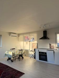 a living room with a table and a kitchen at Bokskogen stugby in Habo +6 photos