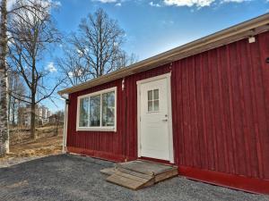 a red building with a white door and a window at Bokskogen stugby in Habo