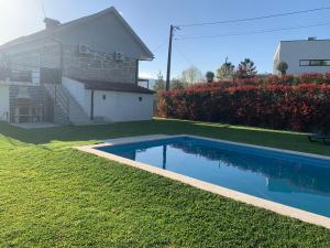 a swimming pool in a yard next to a house at Quinta da Capela in Celorico de Basto