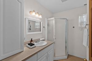 a white bathroom with a sink and a shower at Wapato Lake Waterfront Retreat in Manson +20 photos