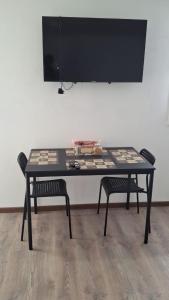 a table with two chairs in front of a wall at Mini dpto interior Río Maule in Talca +7 photos
