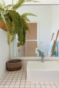 baño con lavabo blanco y planta en Coco Beach II - Seaside Home , Pool , Beach at 200 meters, en Grand Baie