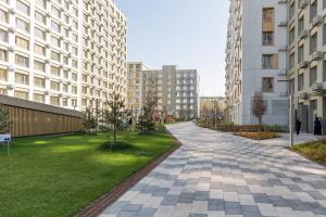 une rue vide dans une ville avec de grands immeubles dans l'établissement GlowNest Apartment Near Mega, à Almaty