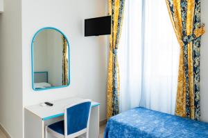 una camera con specchio, letto e scrivania di HC Pineto a Pineto
