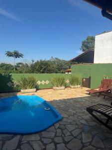 une piscine bleue dans une cour avec un patio dans l'établissement Cores da Mata - Casa de Charme, à Tiradentes